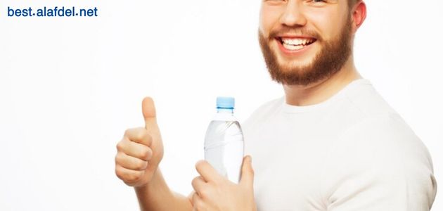 A picture of a person holding a water bottle and making a sign with his hand to express that drinking water is a way to prevent diabetes